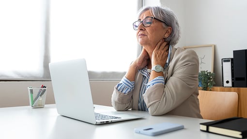 Tired woman sitting at desk in front of a computer