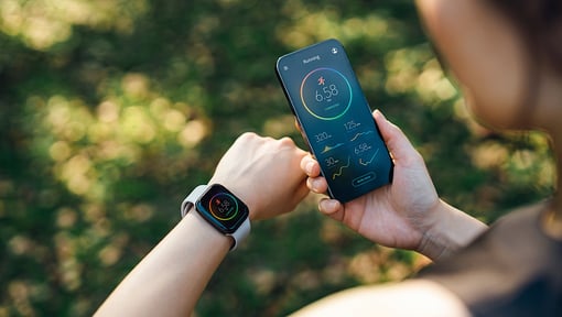 person outside looking at their phone tracking their outdoor run