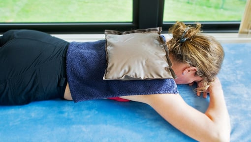 woman doing cold therapy on her back to relieve pain
