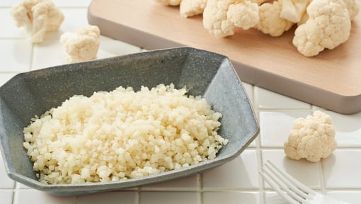 cauliflower being cut and prepped to make cauliflower rice