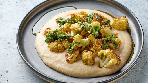 steamed cauliflower with some veggies over a dip