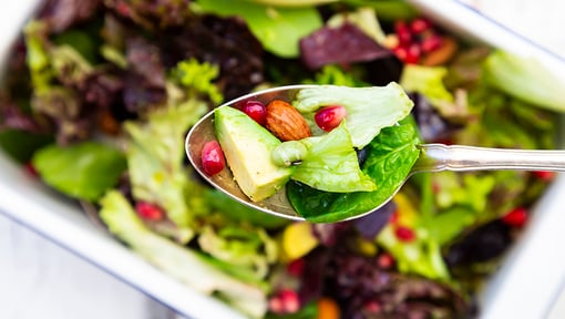 healthy salad with avocado, nuts, and seeds