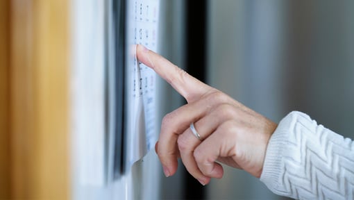 a persons hand pointing at a calendar