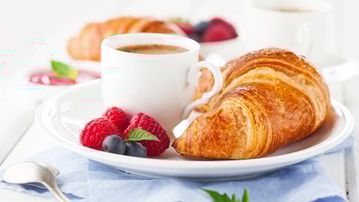 coffee and pastry on a plate with fruit