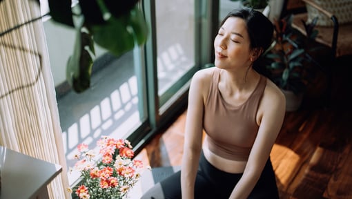 woman sitting in her home taking a moment for reflection with her eyes closed
