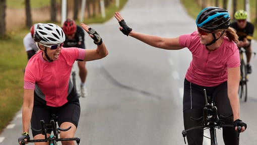 two women high-fiving after a fitness bike ride