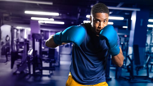 man at the gym with boxing gloves on doing a punch