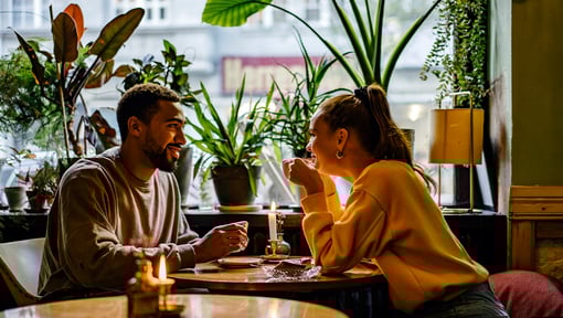 two people out to dinner speaking very closely together