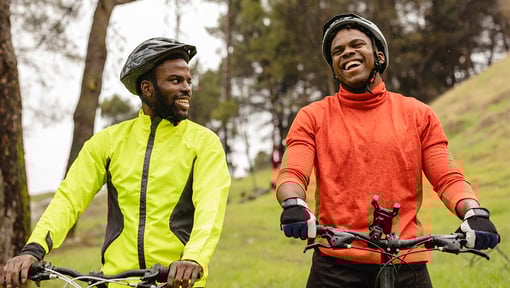 two men outside on bikes