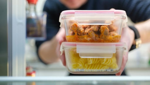 Someone putting their meal prep leftovers into the fridge