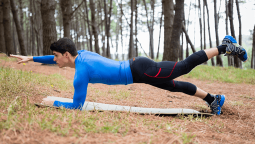 A man outside in his workout gear doing a strength training walking plank