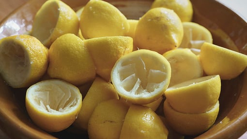 Close-up of a bowl filled with halved squeezed lemons, commonly used for cleaning and deodorizing purposes.