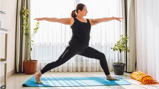 Woman doing yoga exercise in living room