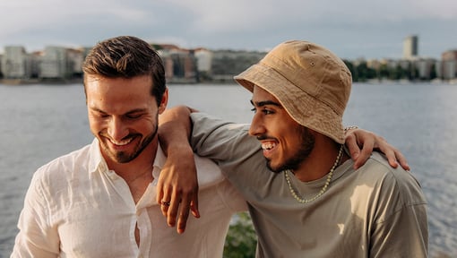 Two people standing close together outdoors with arms around each other’s shoulders