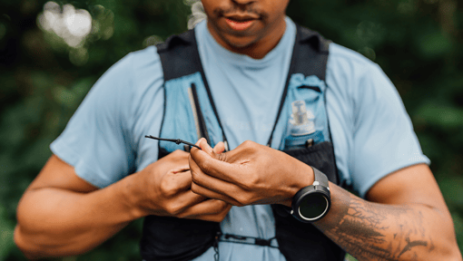 Person wearing a light blue shirt and a black weighted vest for fitness