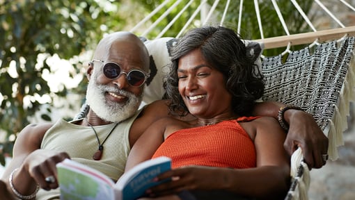 Two people sitting in a hammock enjoying their dream low-key vacation.
