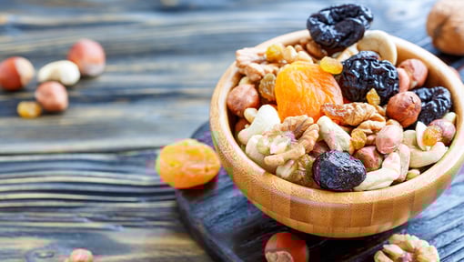 An overflowing bowl of dried fruits and nuts, showing a healthy alternative to ultra processed foods.
