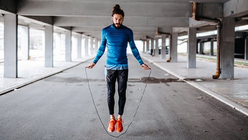 A man is jumping rope while doing a full body mini circuit workout