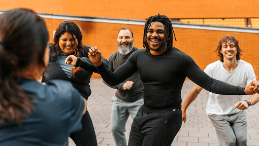 A group of people doing some mood boosting dancing outdoors, enjoying the movement and getting into a flow state