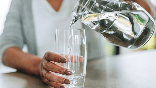  A person pouring water into a glass