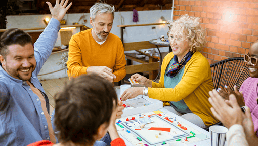 Adults sitting around a table playing a board game.