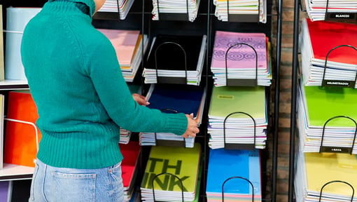 A person shopping for school notebooks at a store. 