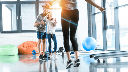 A family in a fitness center together jumping rope and cheering each other on.