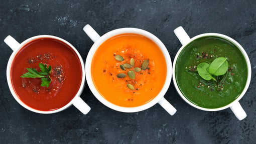 Three colorful pureed soups served in cups, offering a variety of vegetable-based meal options.