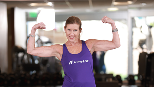 Active&Fit member demonstrating strength and fitness progress in a gym setting surrounded by exercise equipment.